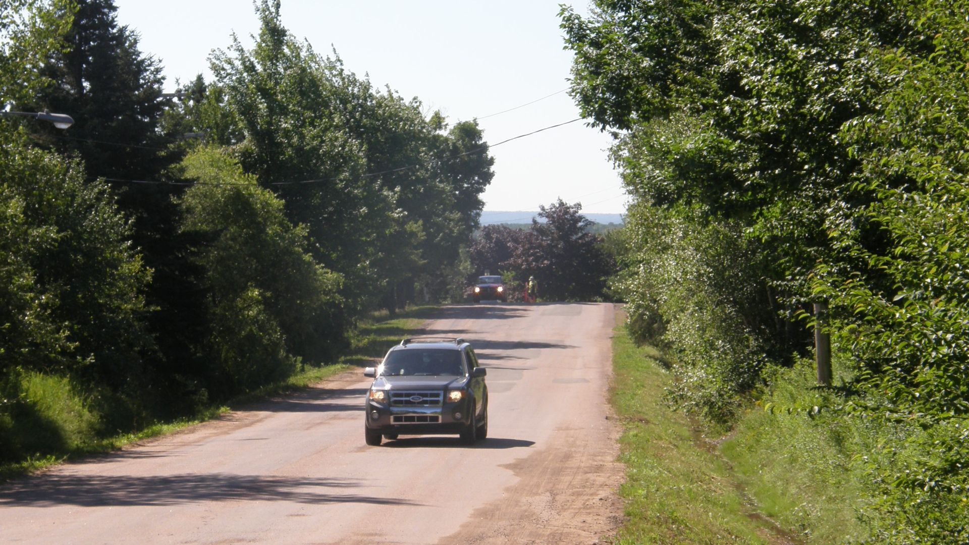 A view from the white post at Magnetic Hill in Moncton, New Brunswick. The actual lowest point in the road is behind the first vehicle.
