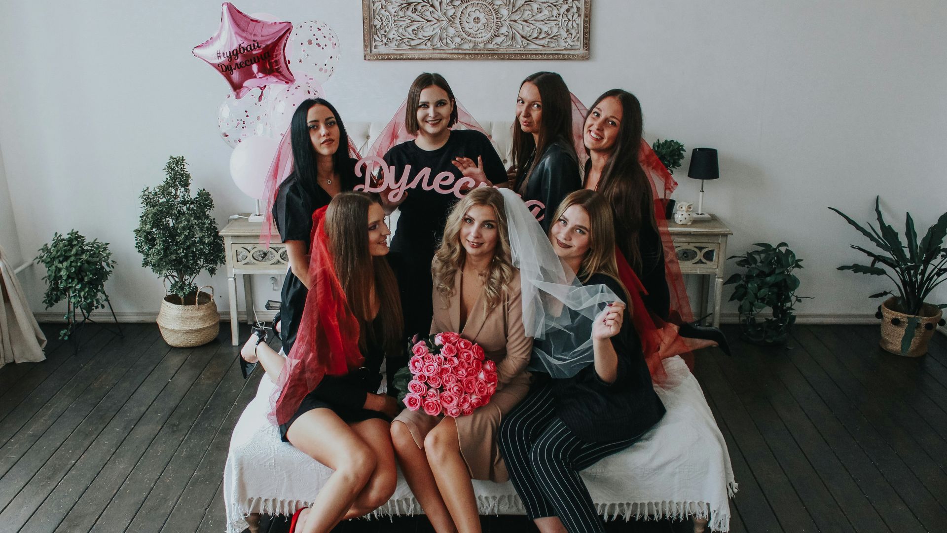 4 women sitting on white couch