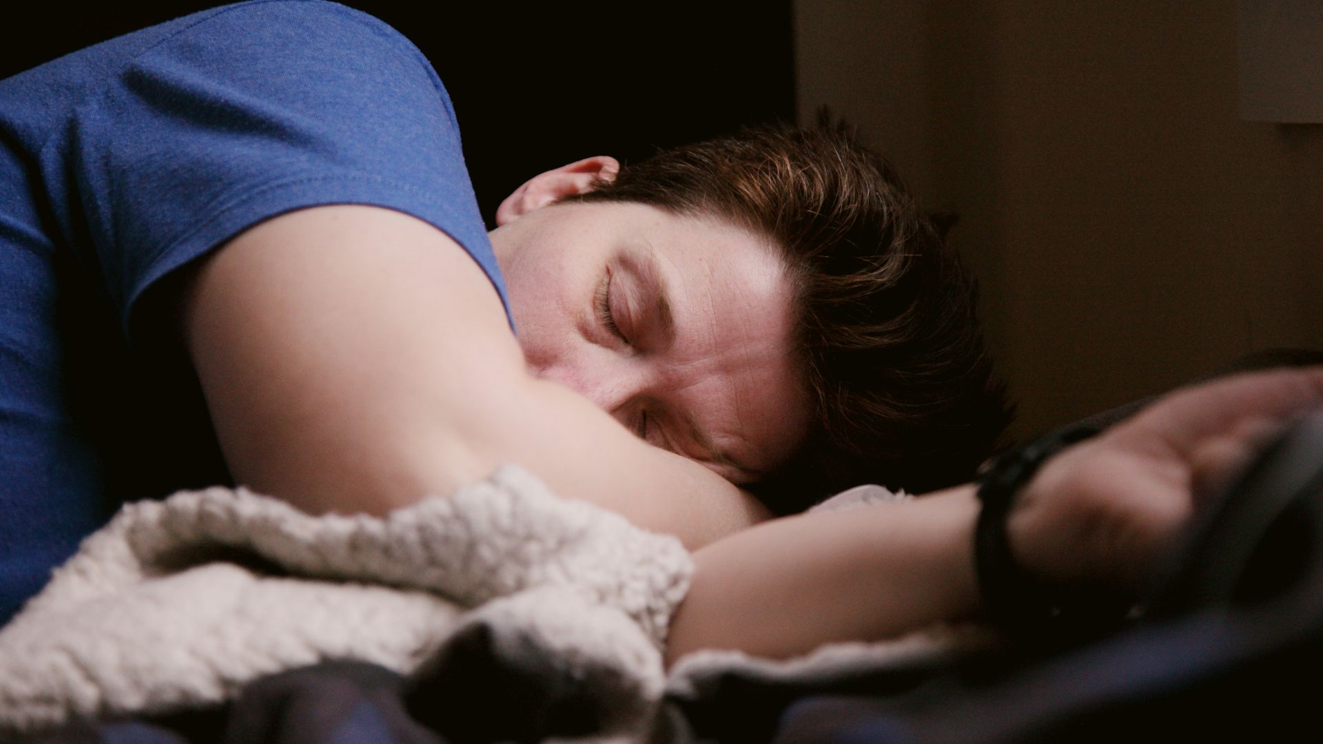 man in blue shirt sleeping