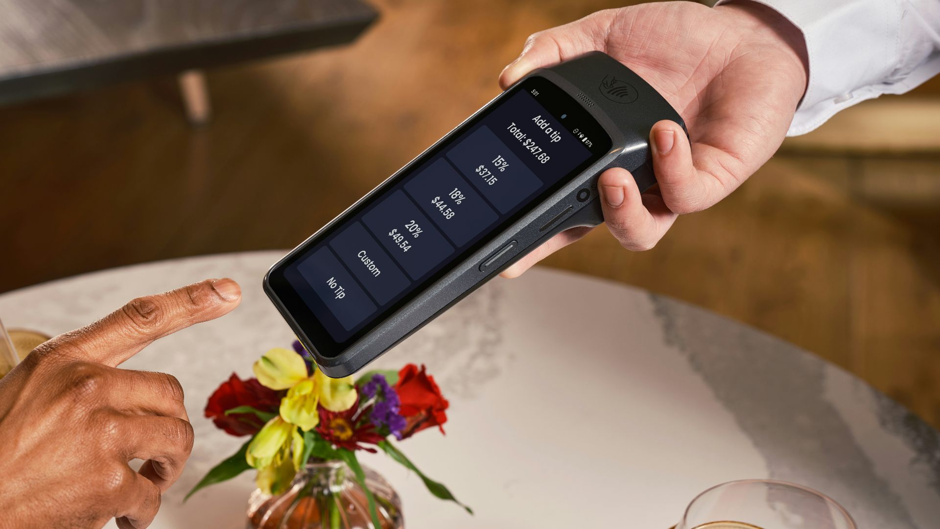 Customer points at payment terminal in restaurant