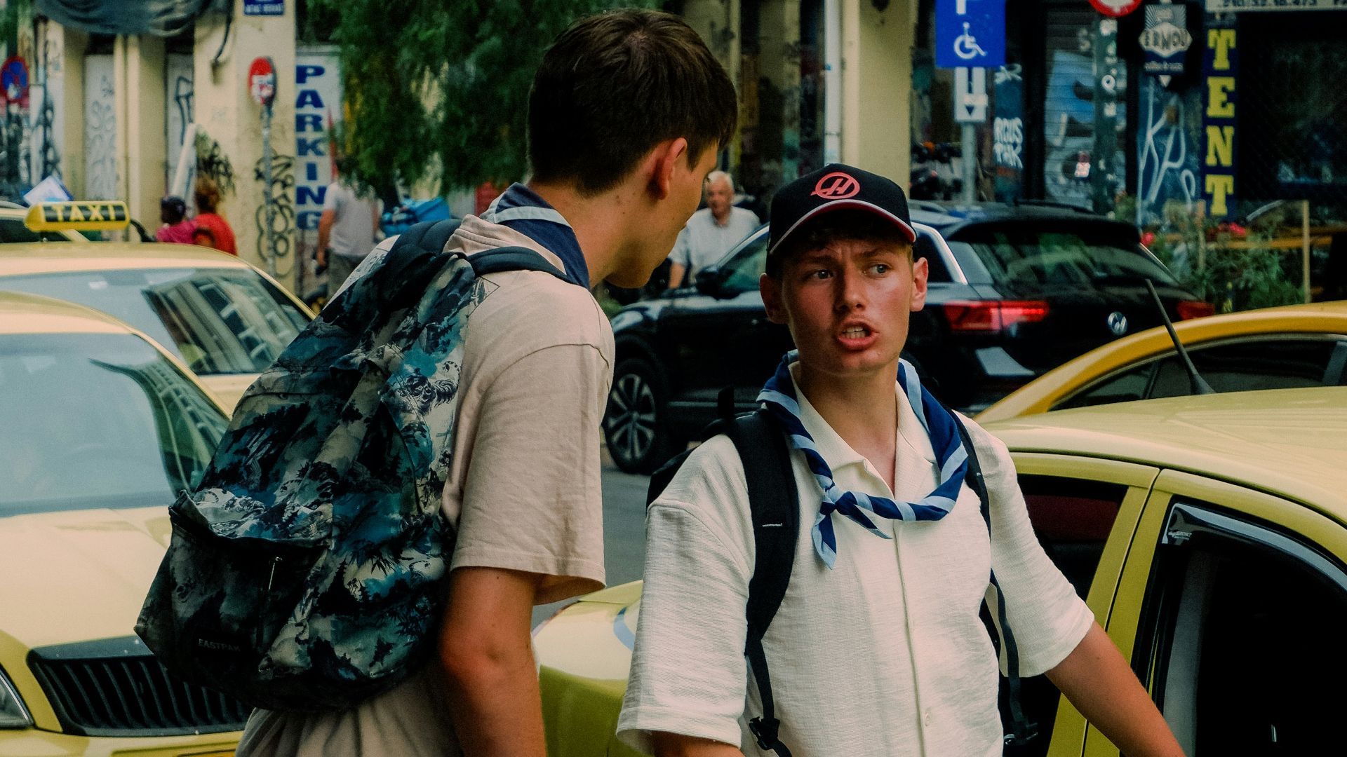 A couple of men standing next to each other on a street