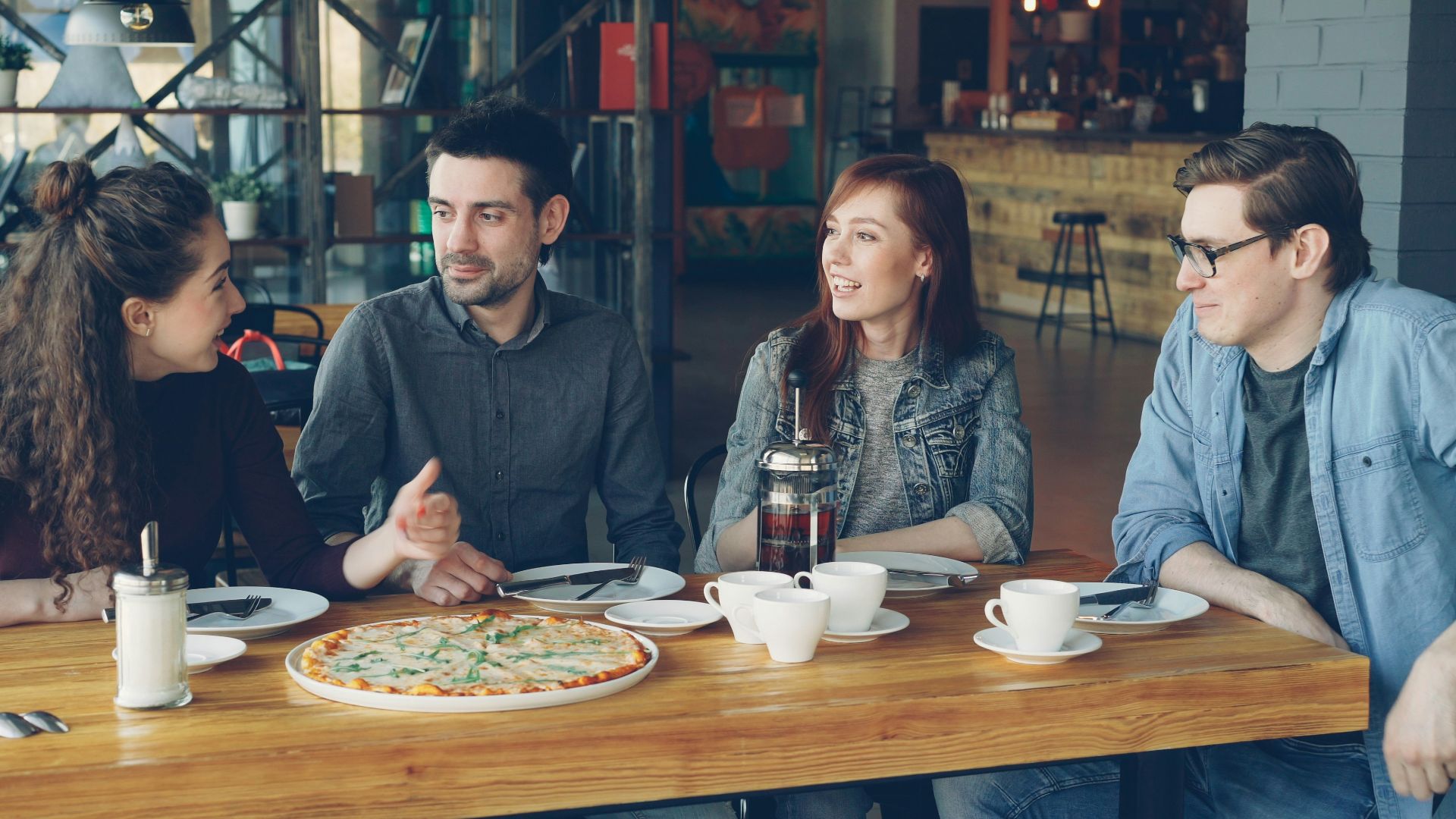 Friends enjoy pizza and conversation in a restaurant
