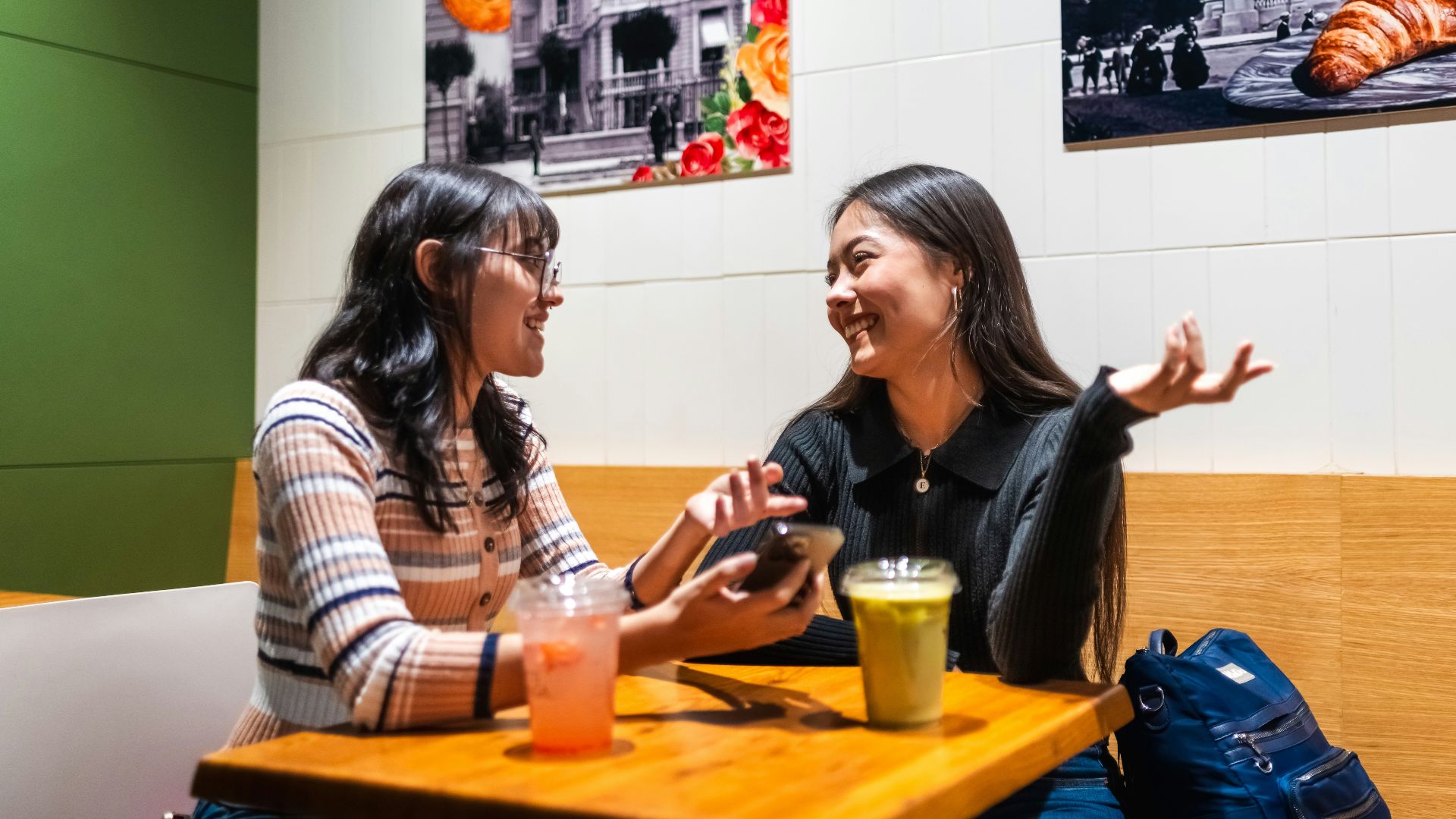 Two young women talking at a cafe table
