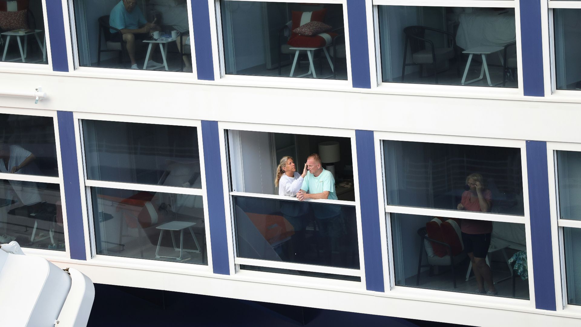 Two people looking out a window on a building