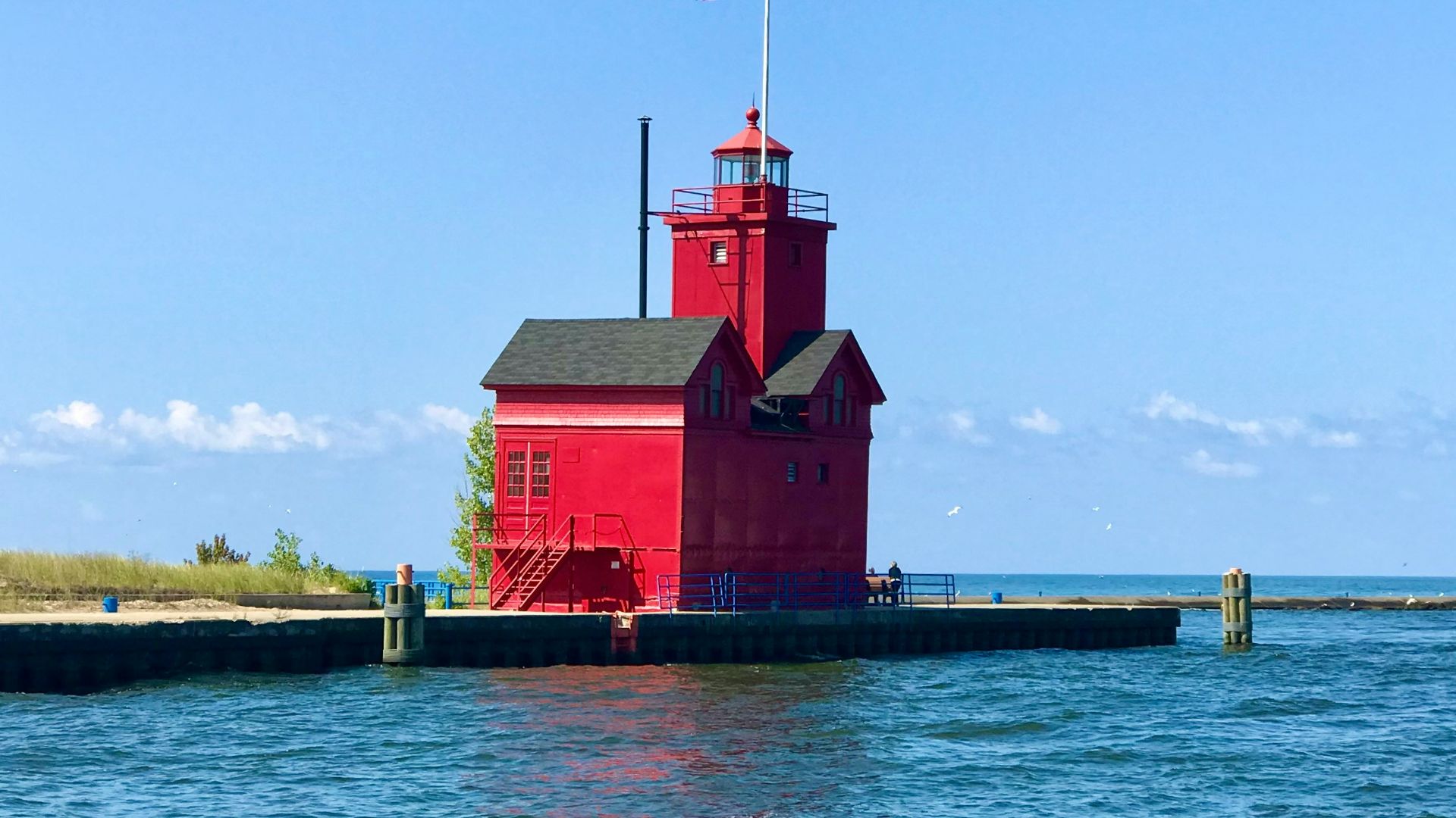 a red lighthouse with a flag on top of it