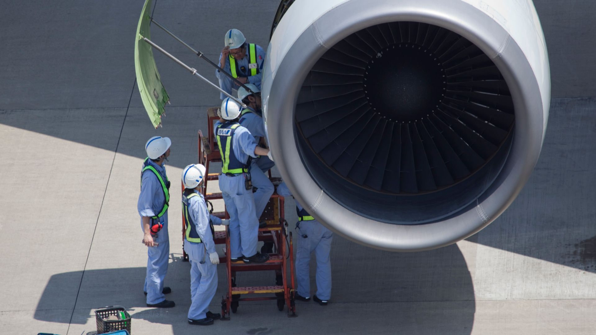 ANA maintenance personnel inspecting an airliner turbofan engine at Tokio-Haneda airport