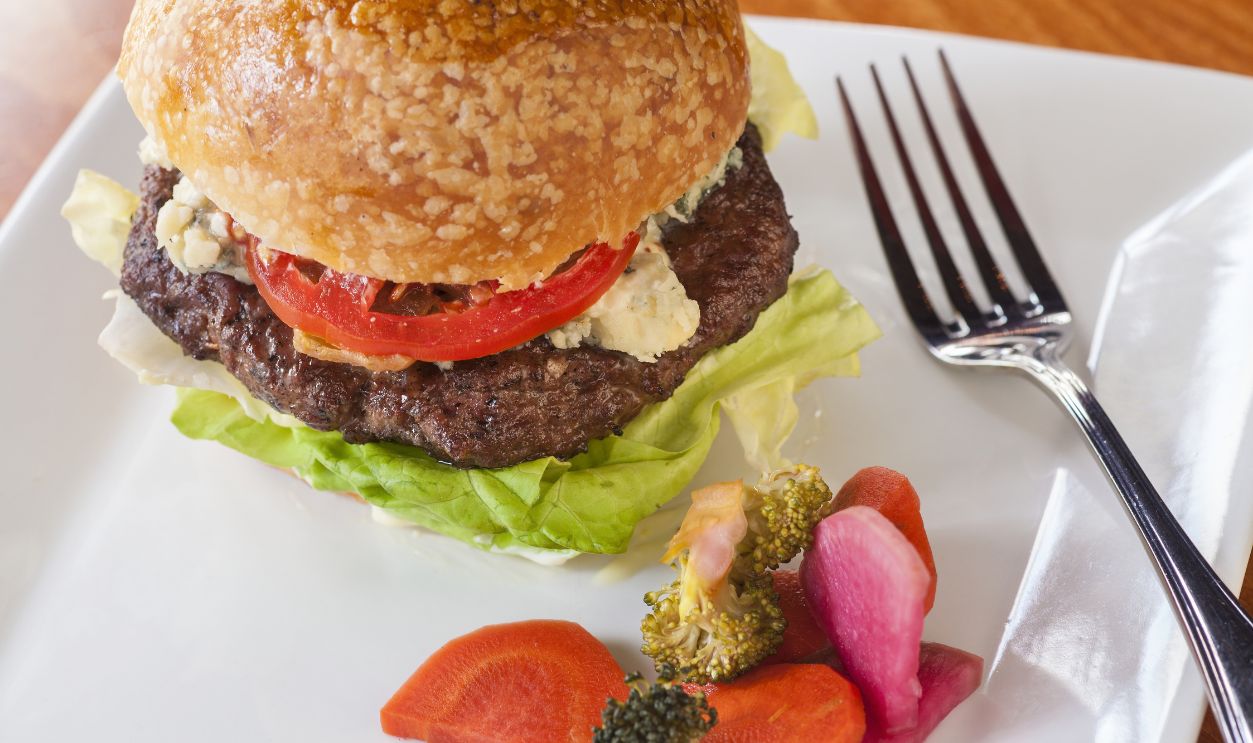Burger with caramelized onions, blue cheese and aioli served with pickled vegetables