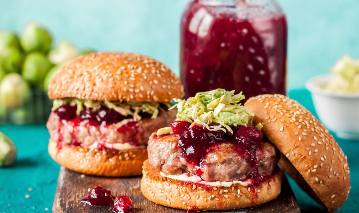 Turkey Burger with Cranberry Sauce and Brussels Sprout Coleslaw, Turquiose Background, copy space for your text