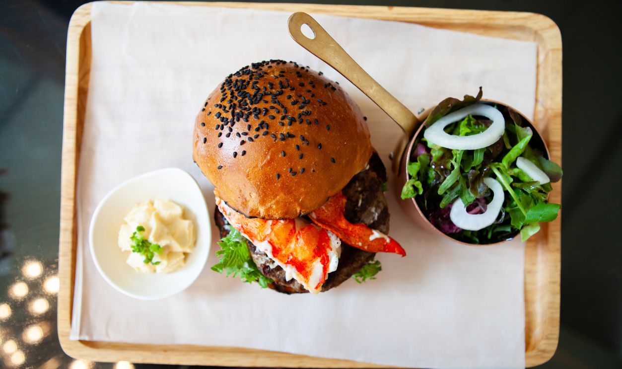 A set of tasty and delicious Maine Lobster hamburger with salad. Not junk food anymore, now hamburger consider as a delicacy and gourmet food. Healthy eating and eat well concept. Top view.