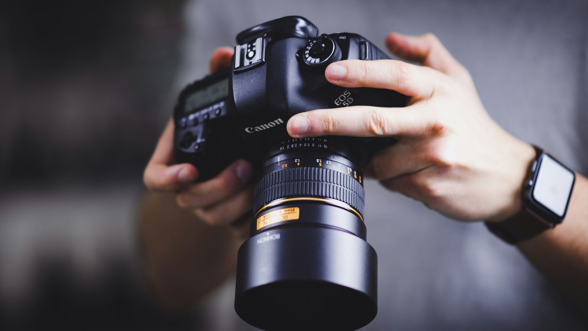person holding Canon DSLR camera