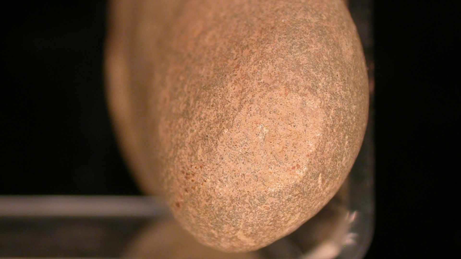 Igneous stone hammer made from a beach cobble, ovoid in profile and sub-triangular in plan. The hammer stone has light impact pecking on the surface of the narrow, pointed end of the tool. This suggests that the tapered end was the striking surface and th