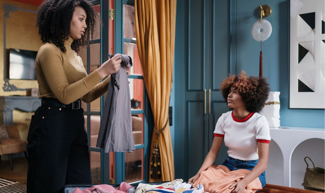 Two women sorting clothes in a modern and colorful living room, showcasing vibrancy