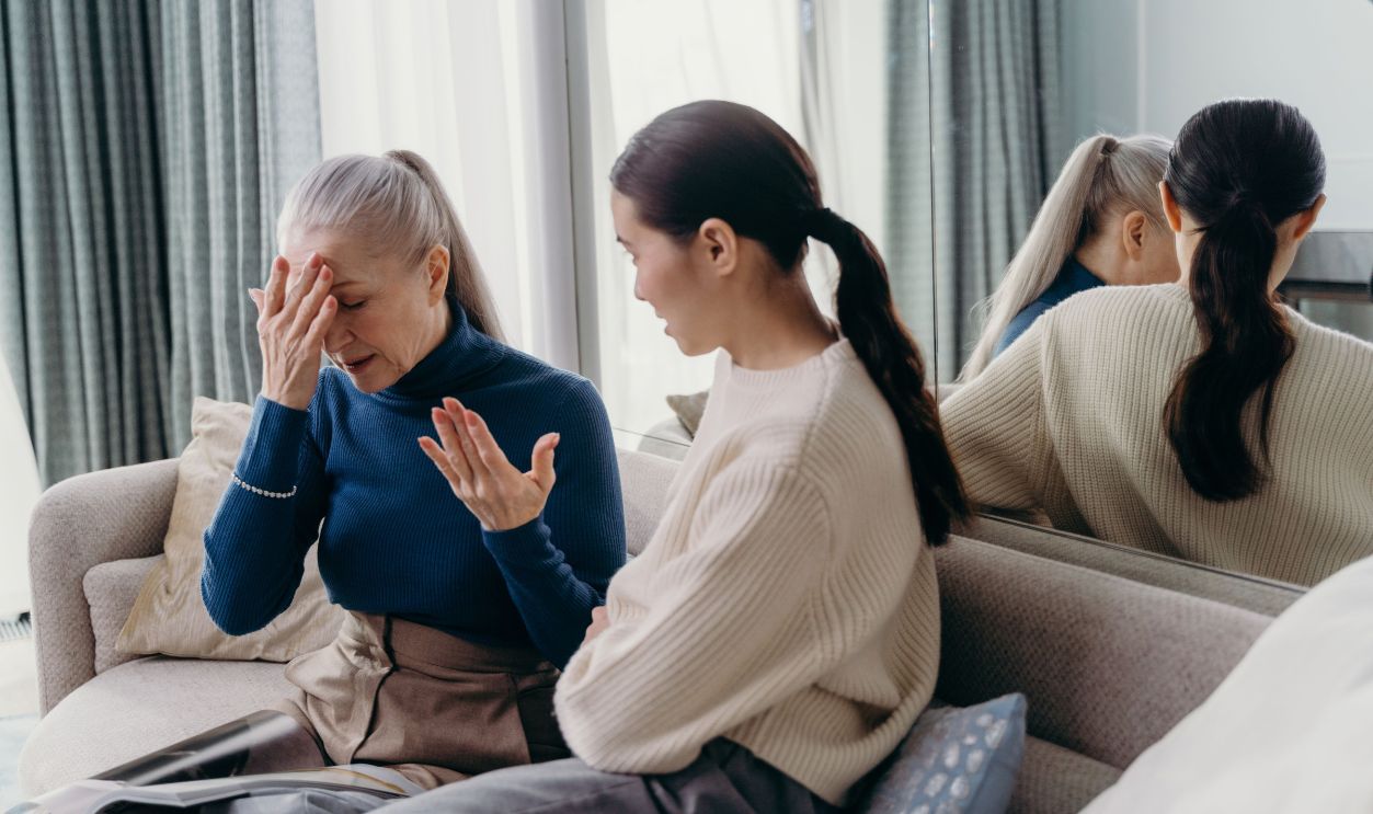 A touching moment of bonding between a mother and daughter sitting on a couch indoors.