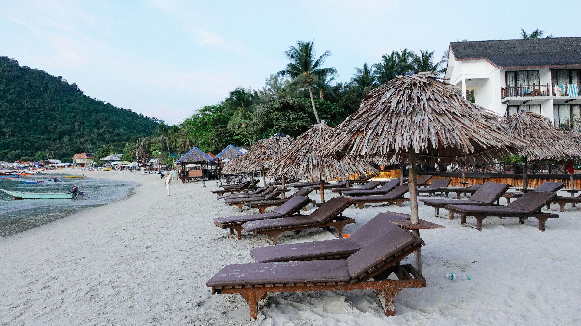 a beach with straw umbrellas