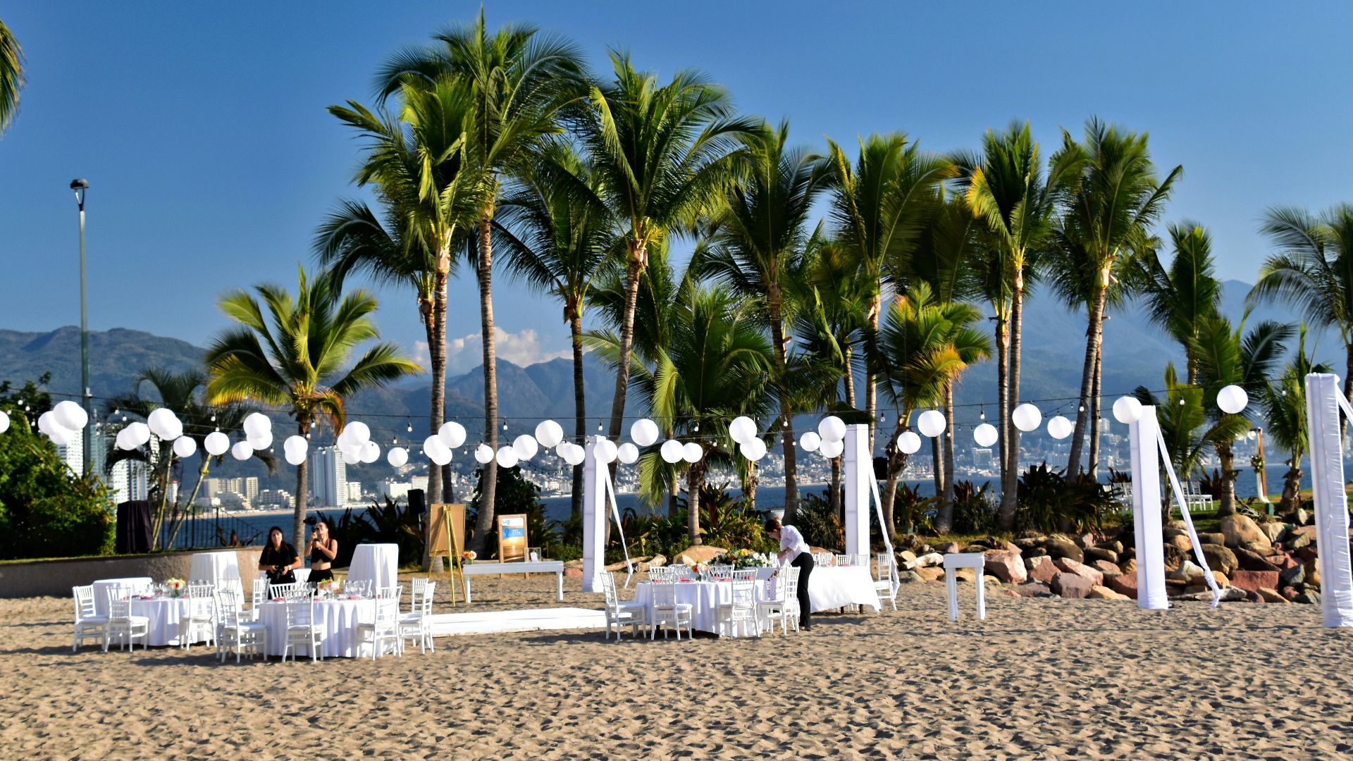 Beach ceremony setup with palm trees and decorations