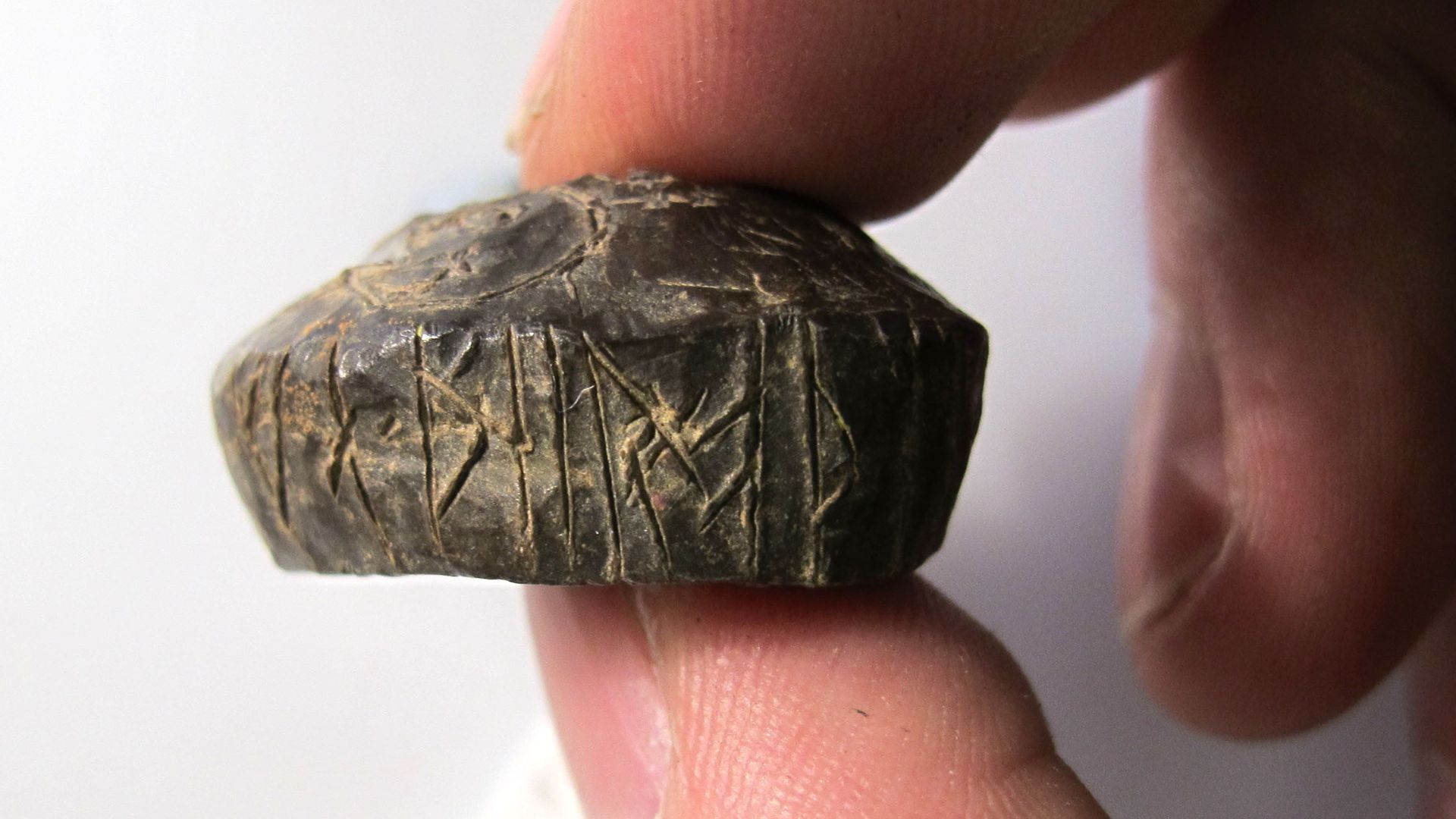 An inscribed lead spindle dating to the early 11th century. The whorl is trapezoid in cross-section and roughly circular in plan. An hour-glass shaped hole has been drilled through the centre, measuring circa 8mm diameter at the opening. The whorl is insc