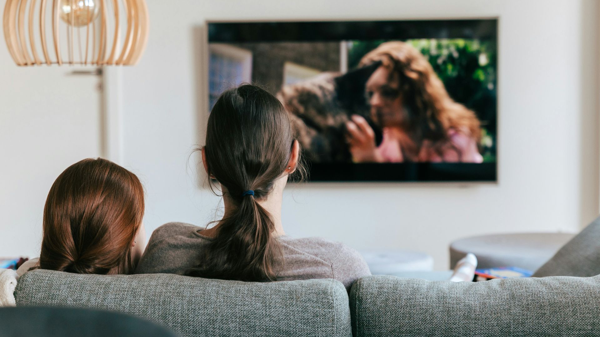 a couple of women sitting on top of a couch