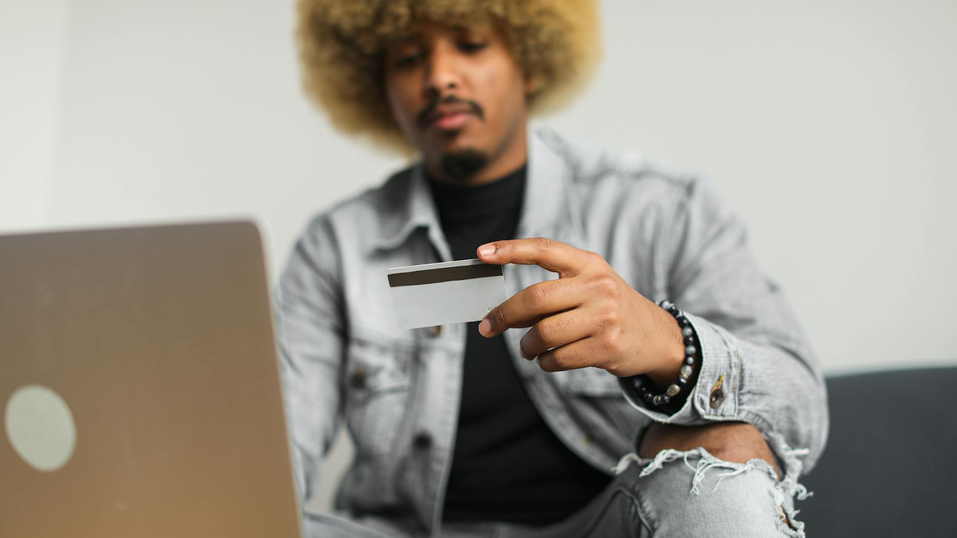 A Man with an Afro Hair Holding a Credit Card