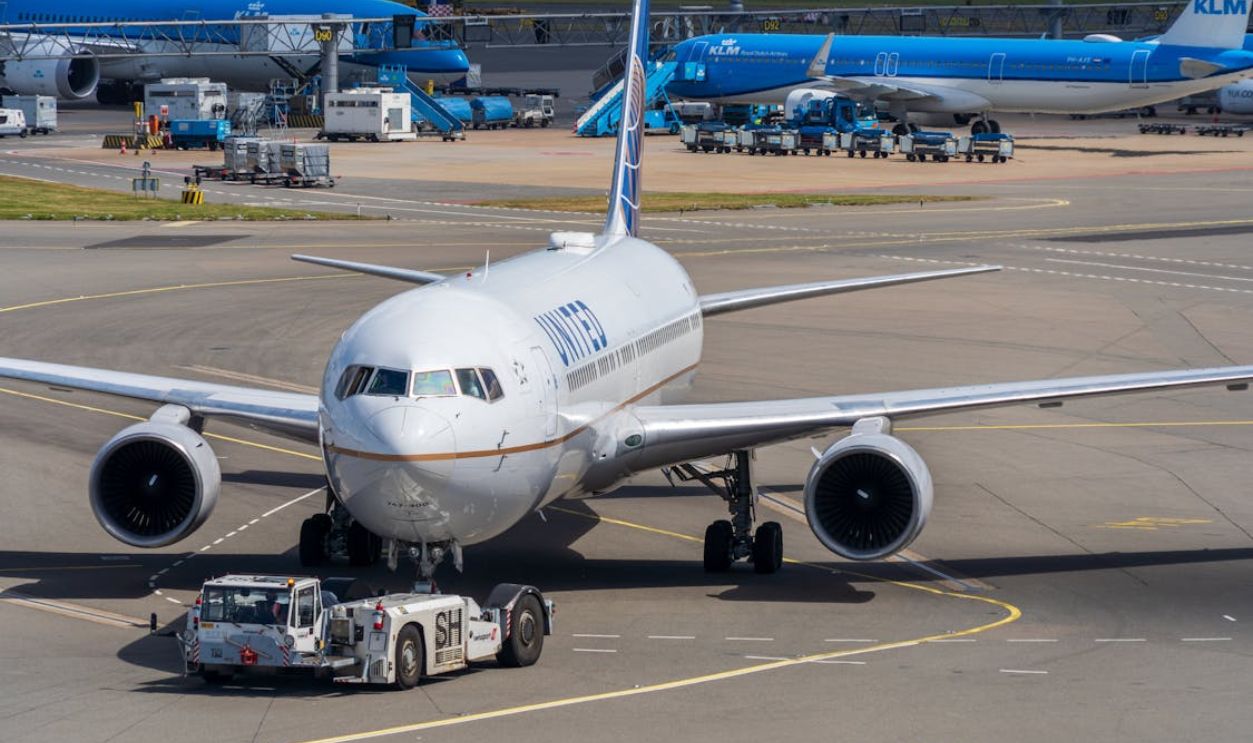 Airplane at Airport with Ground Support Vehicles