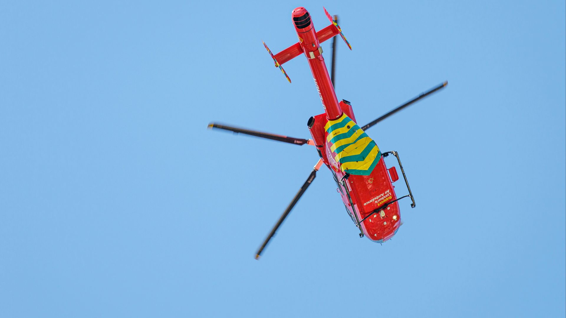 red and yellow helicopter flying in the sky