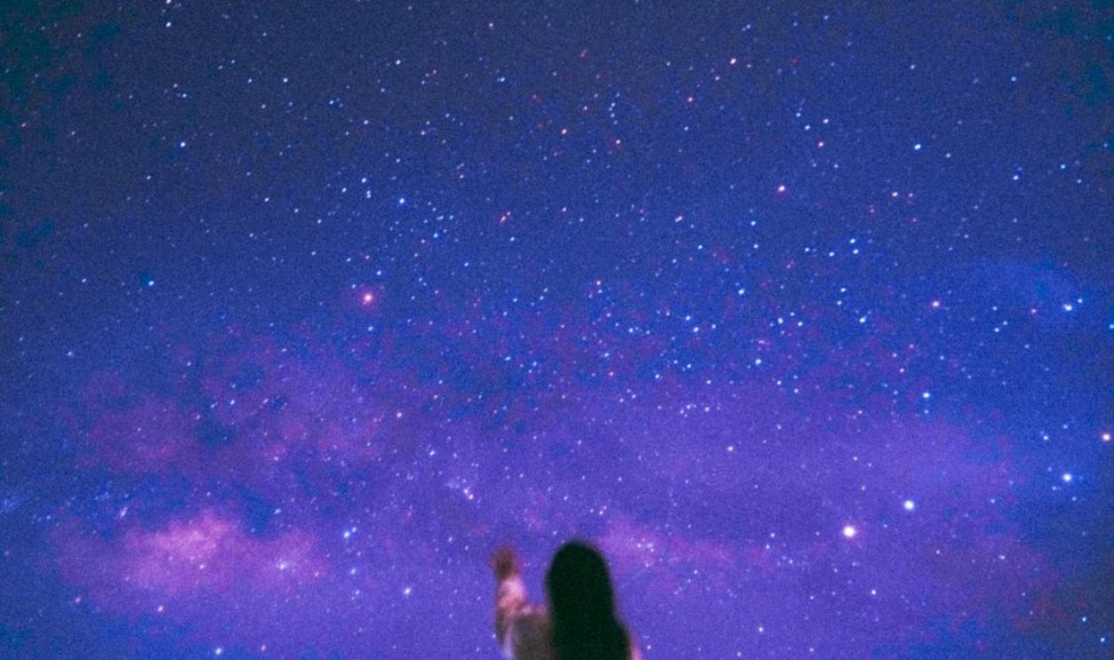 Defocused Photo of a Woman Standing on the Background of a Starry Night Sky