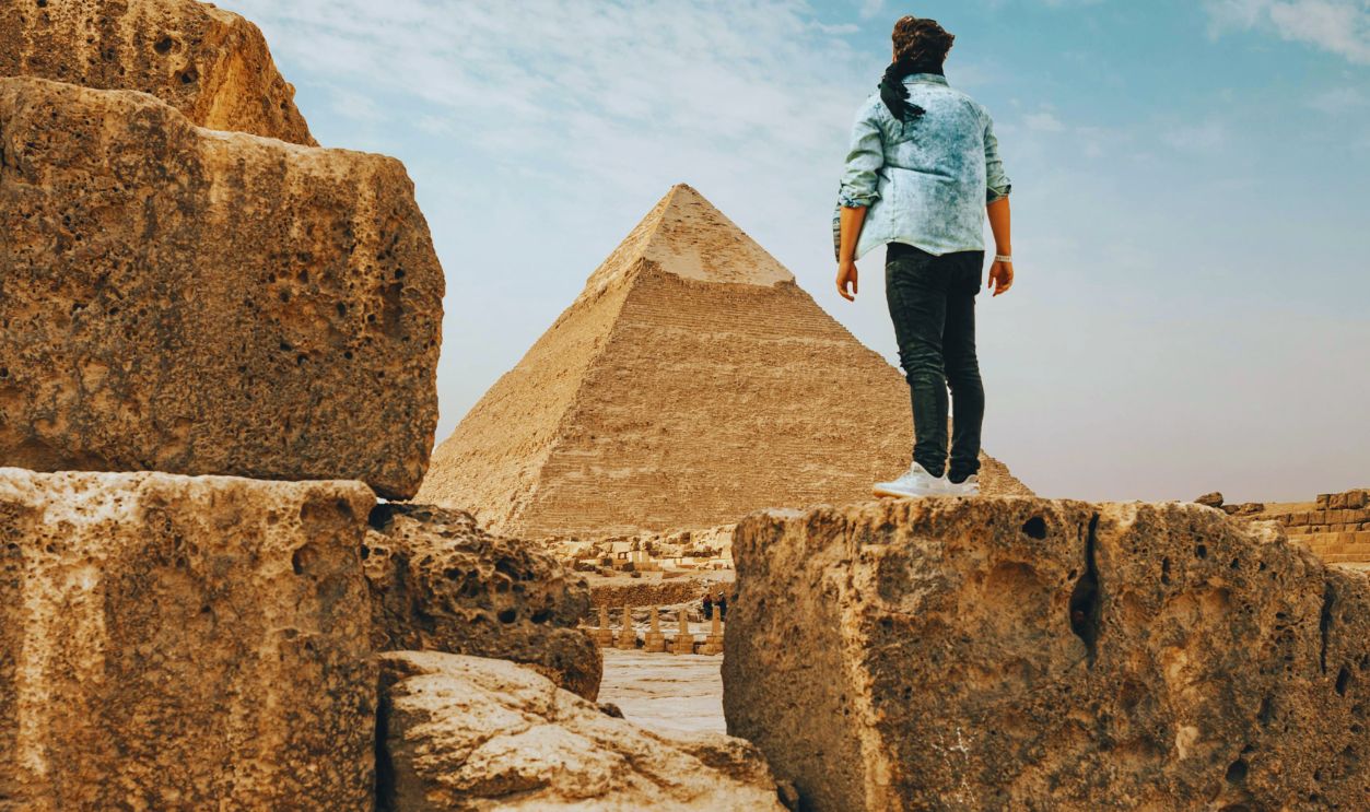 Traveler standing on stone monument in desert