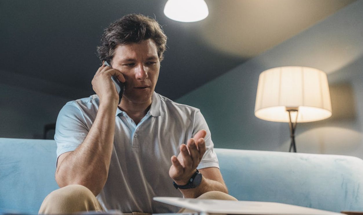 Man Sitting on the Sofa Talking on the Phone