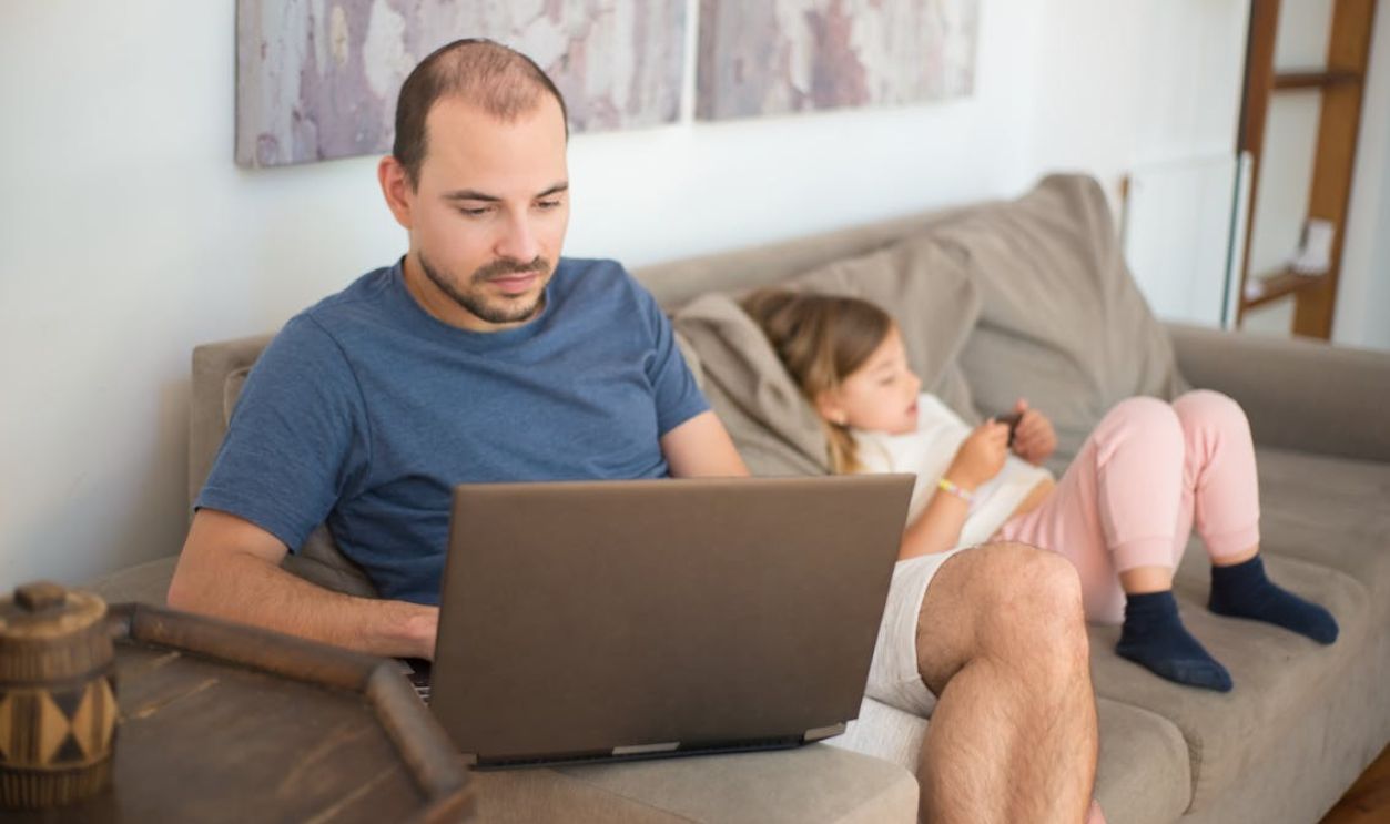 Man in Blue Shirt Using a Laptop