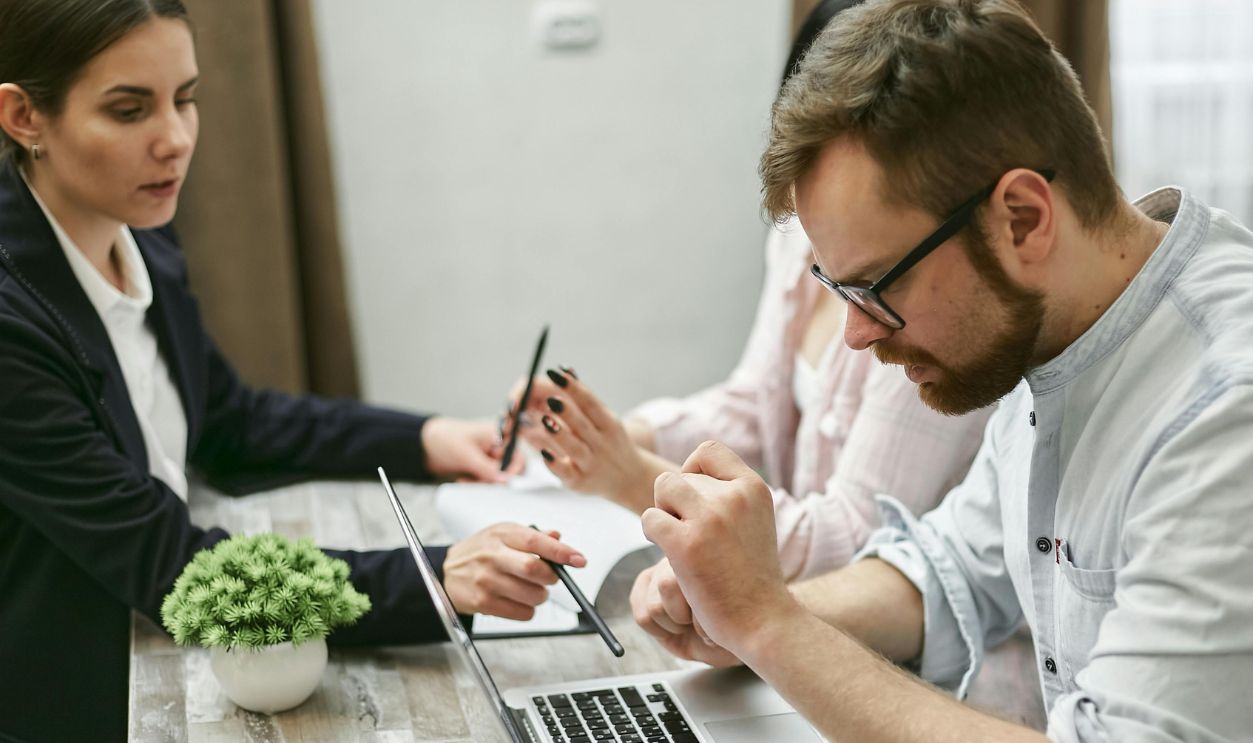 A Bearded Man Looking at the Laptop on the Table