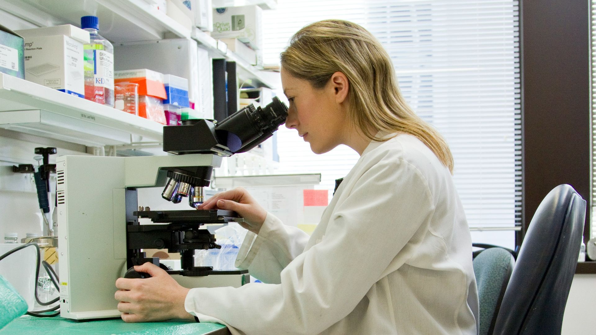woman in white robe sitting on black office rolling chair