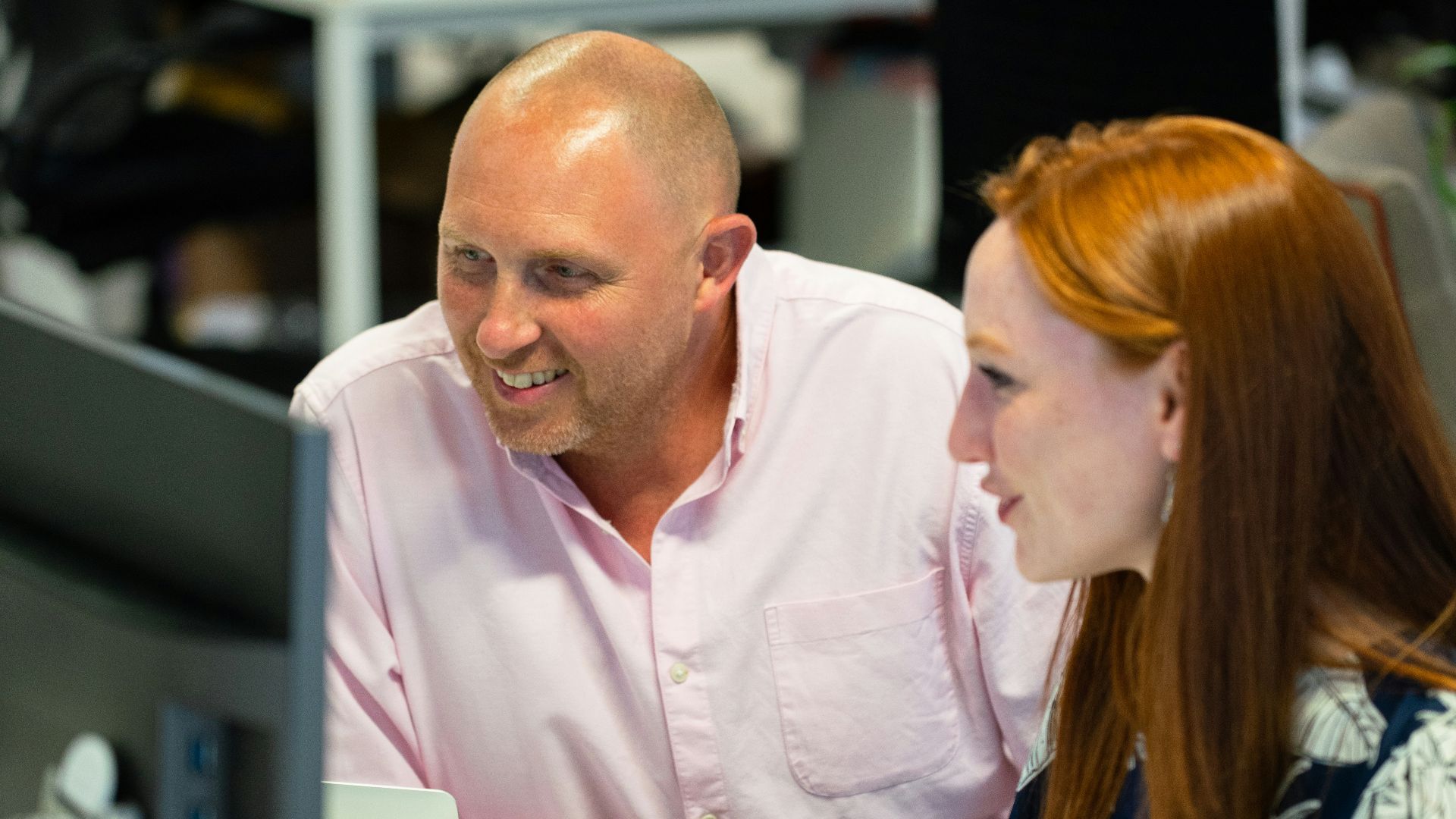 man in pink button up shirt sitting beside woman in blue and black shirt