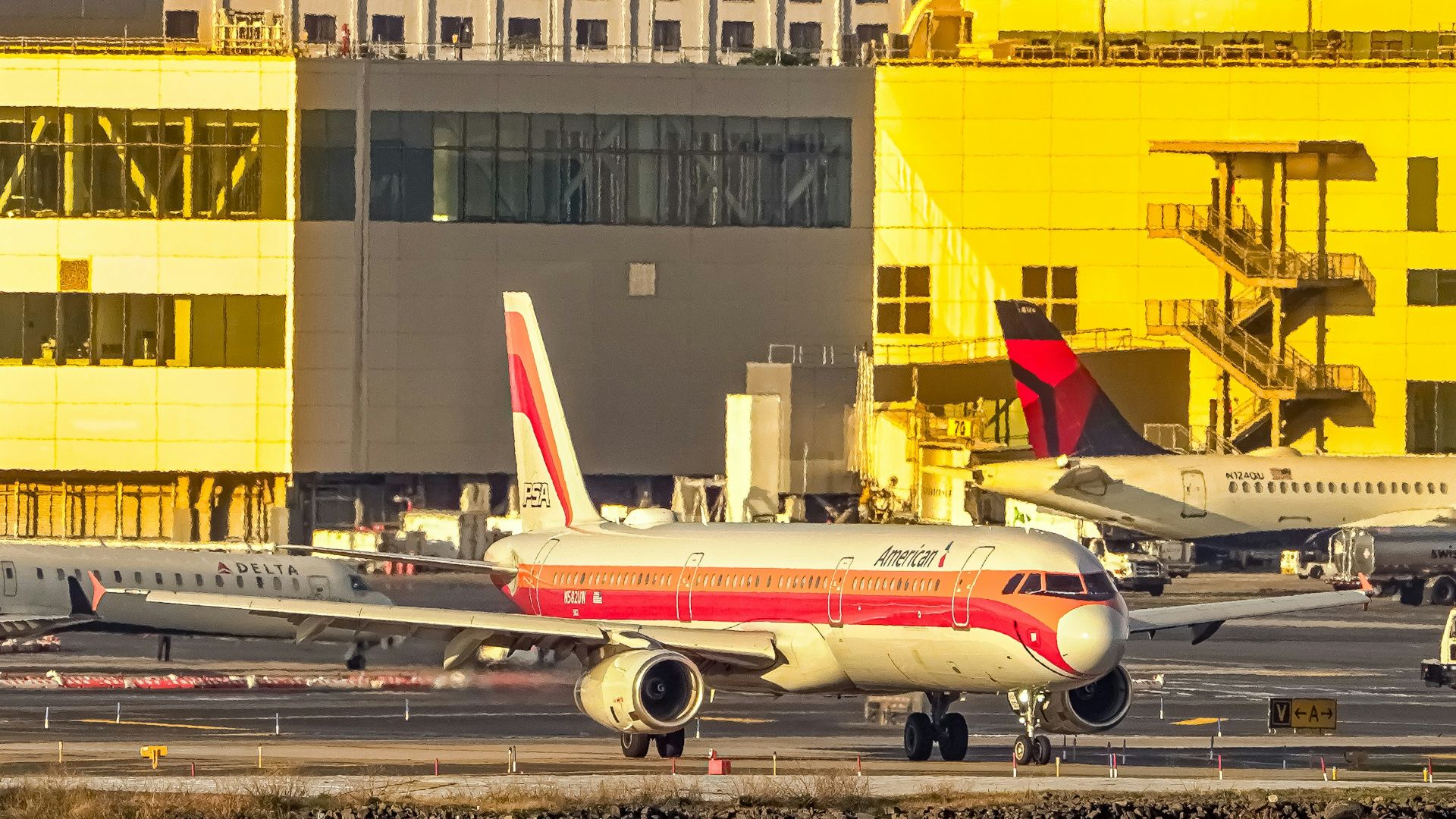 Airplane on tarmac with buildings in background