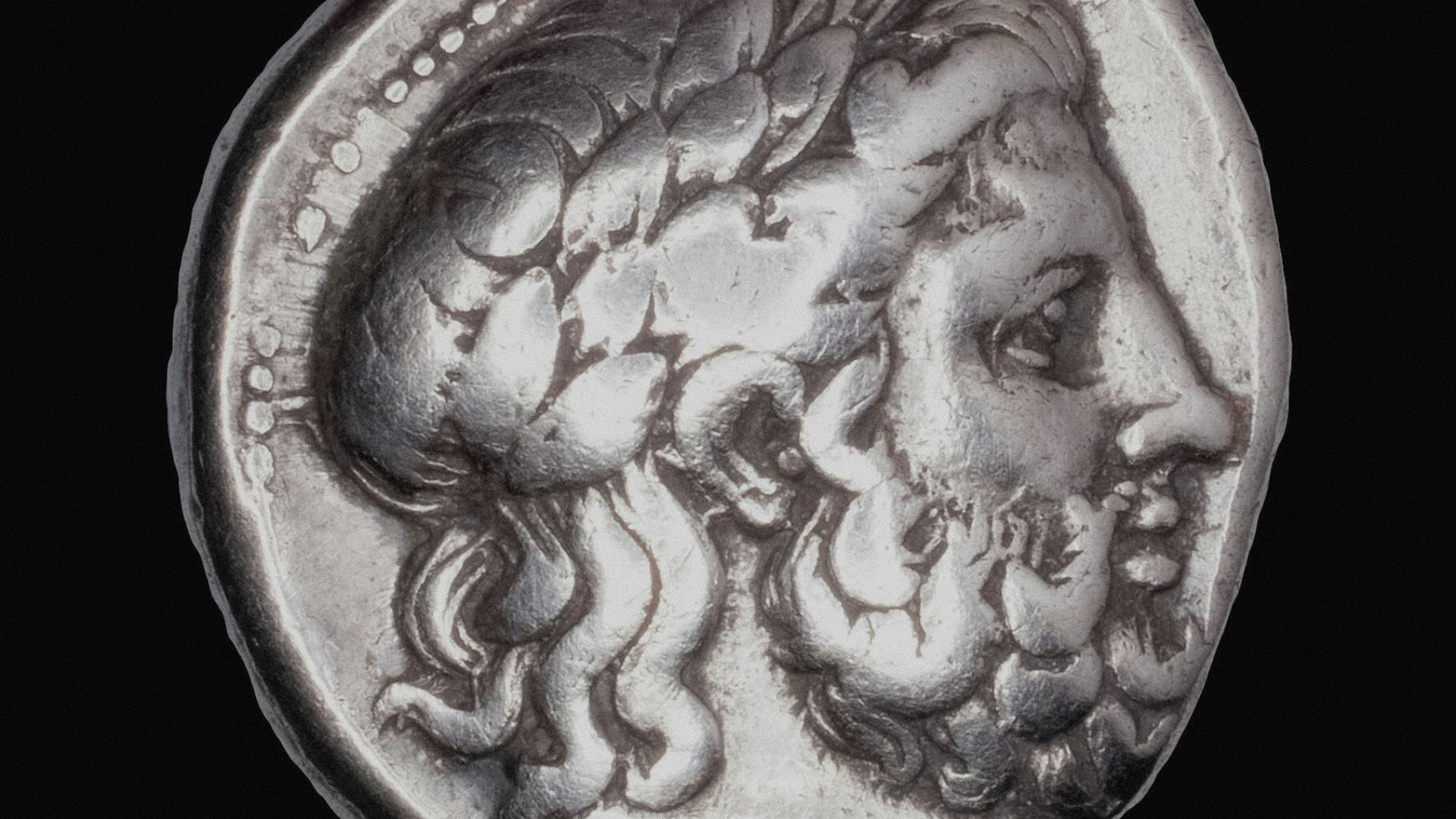 Ancient silver coin with profile of bearded man.