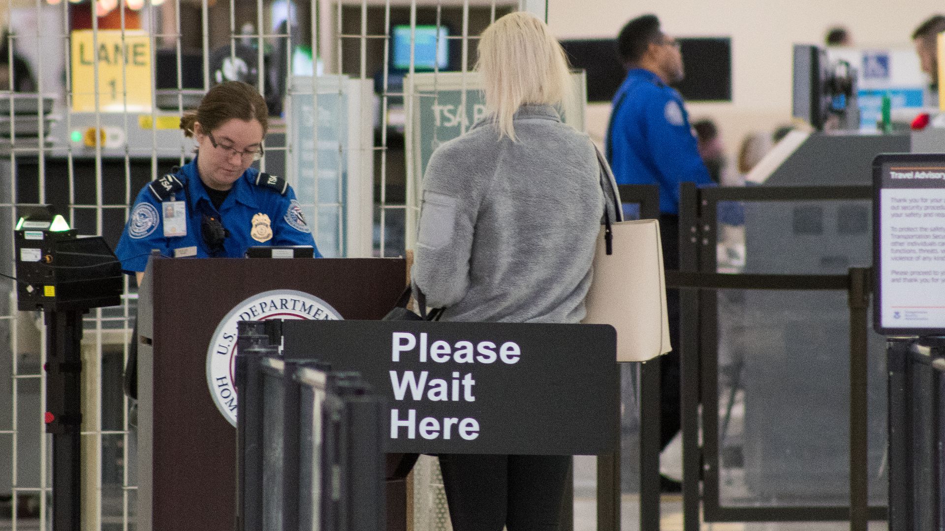 A Transportation Security Administration agent at a checkpoint verifying passenger identification, John Glenn Columbus International Airport