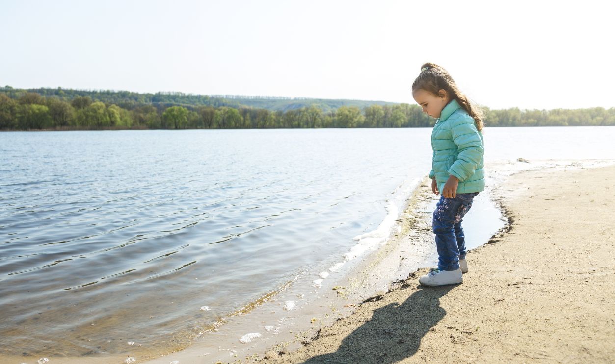portrait of a cute little girl walking outdoors on the beach