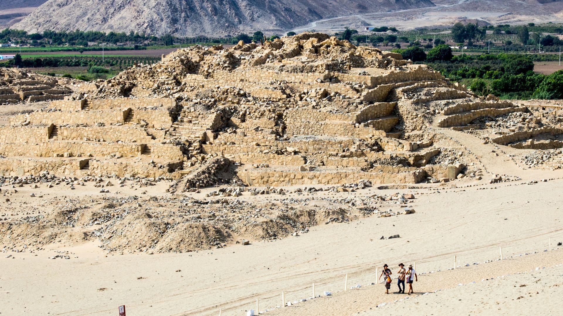 A group of people standing on top of a sandy beach
