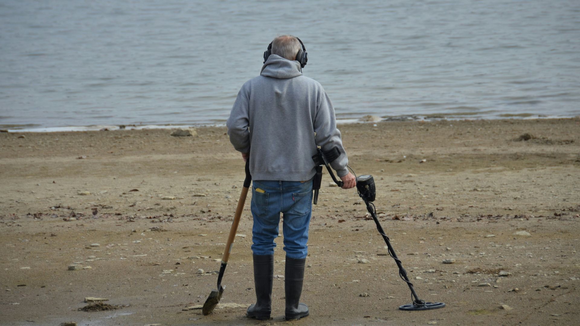 a man with crutches and a cane standing on a beach