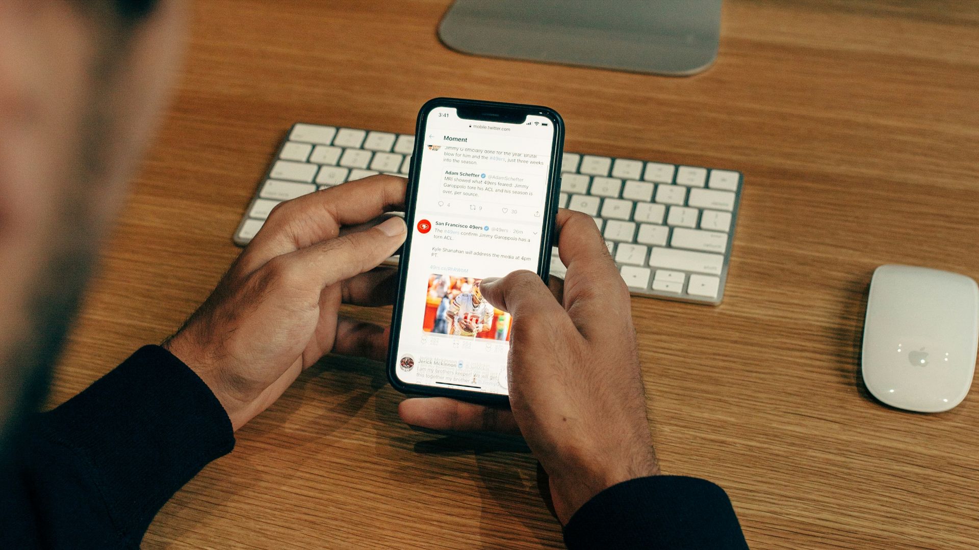 man holding phone while leaning on table