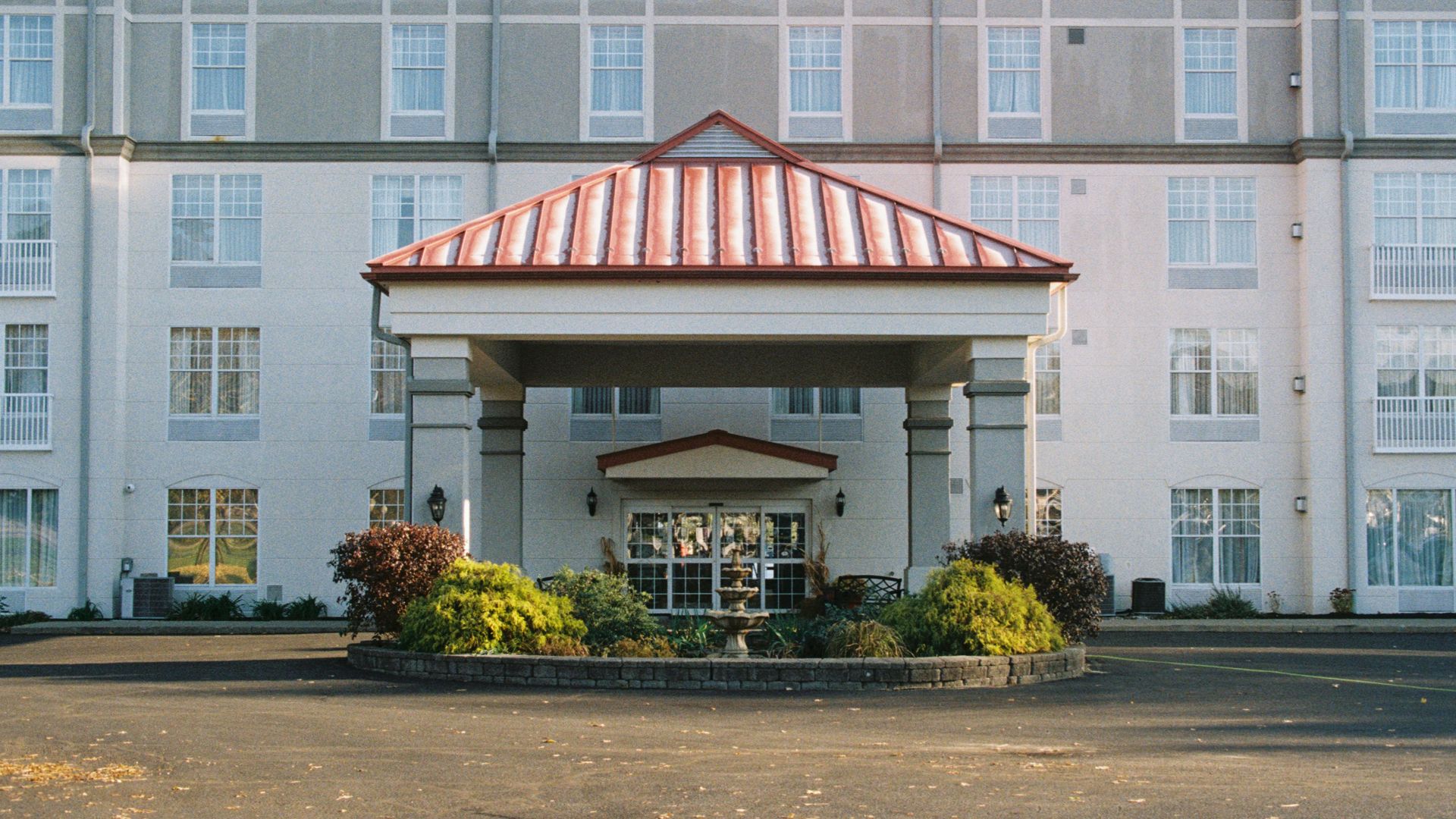 the front of a hotel with a red and white roof