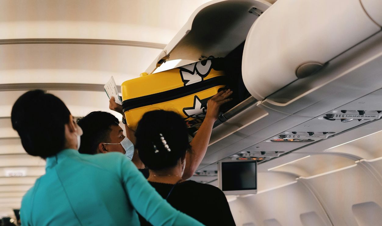 Passengers Putting Their Luggage Inside the Overhead Bin