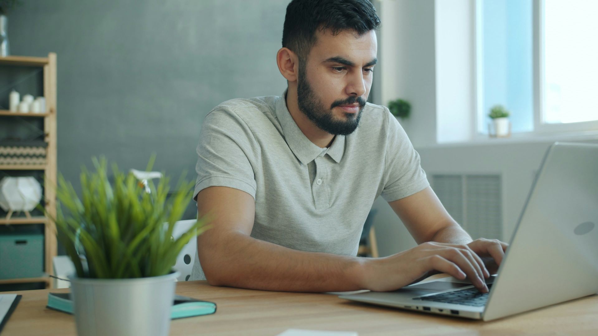 Man typing on a laptop at a desk.