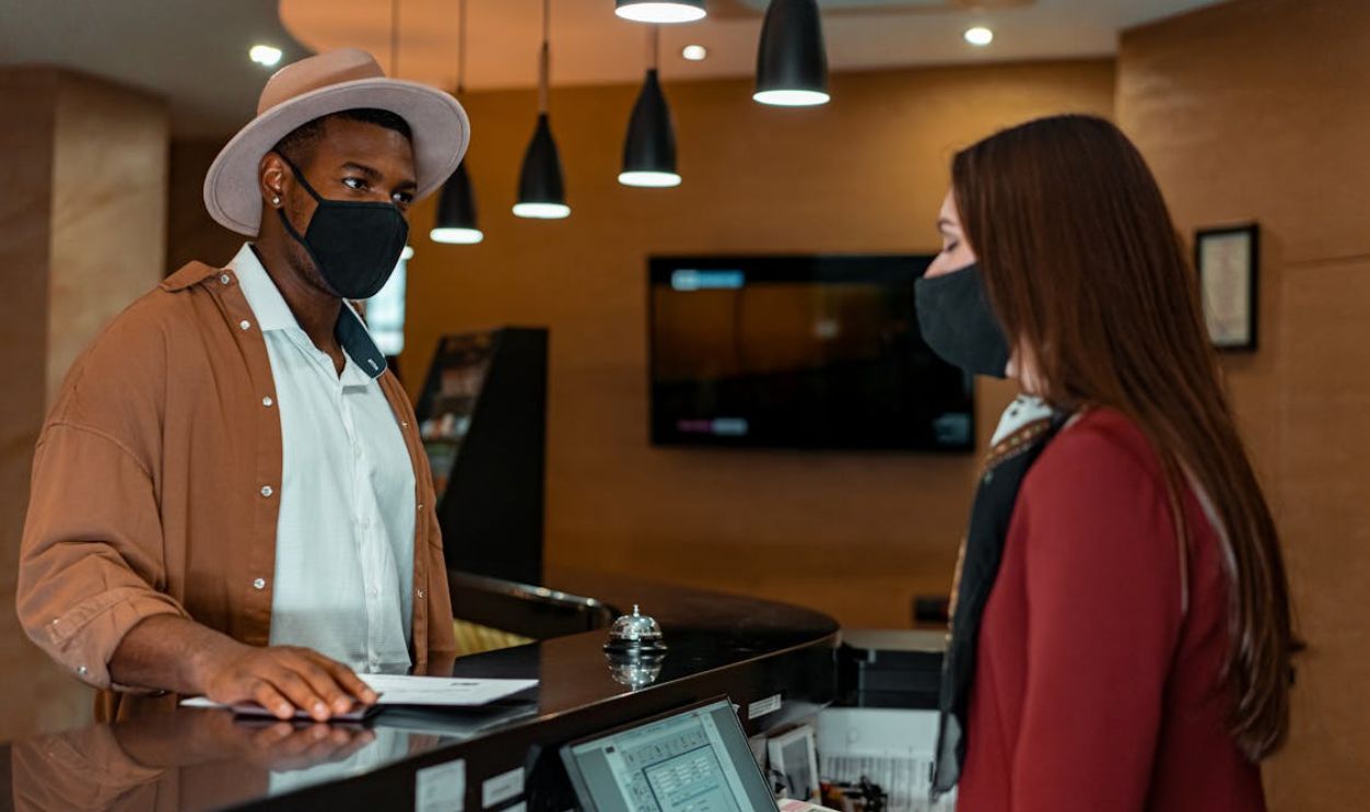 Man Wearing a Face Mask Checking in a Hotel