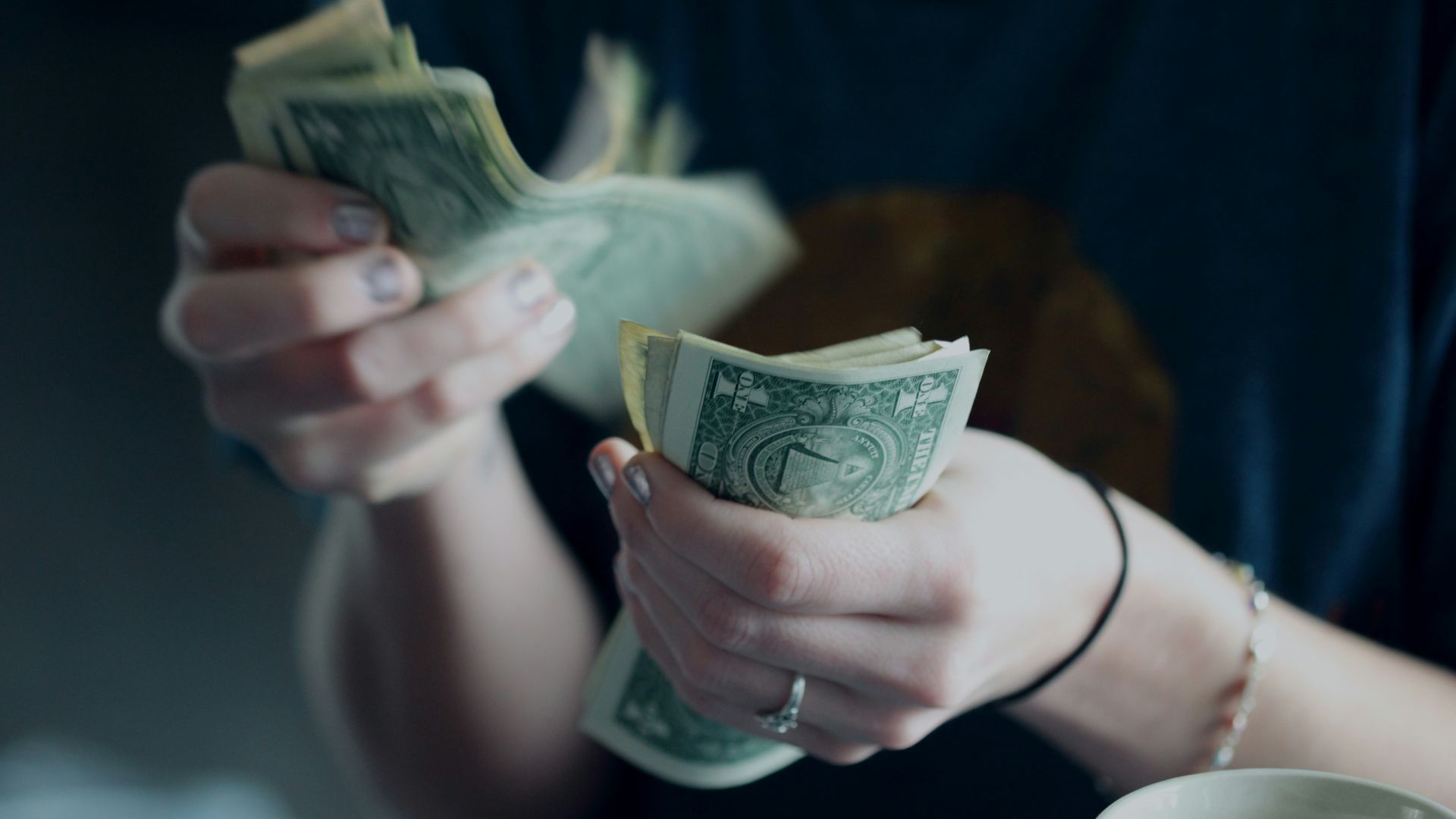 focus photography of person counting dollar banknotes