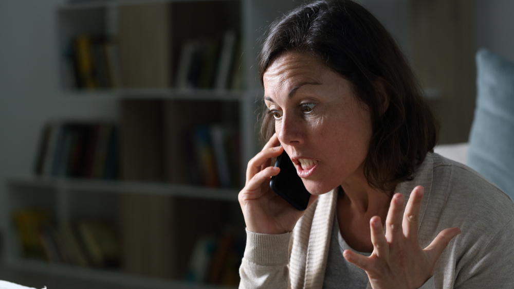 Angry middle age woman calling on smart phone