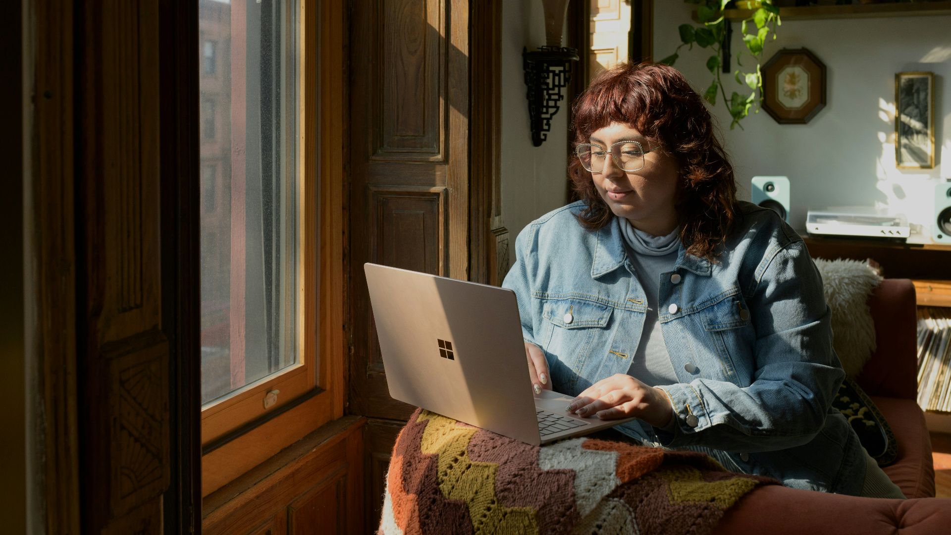 a woman sitting on a couch using a laptop computer