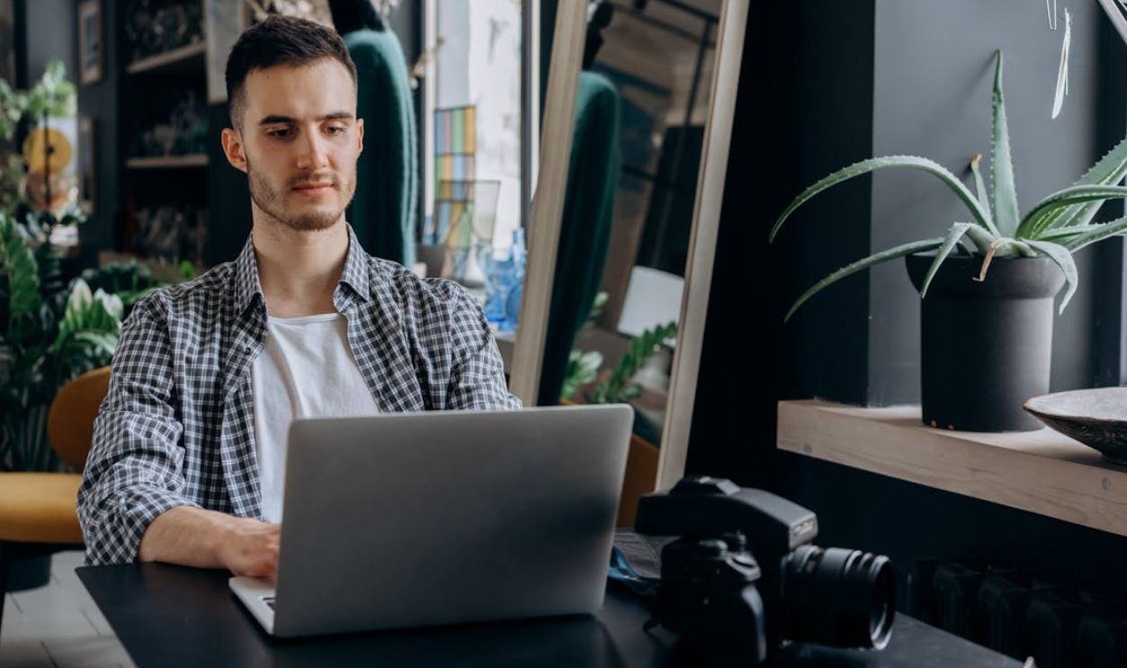 Man in Plaid Shirt Using Laptop