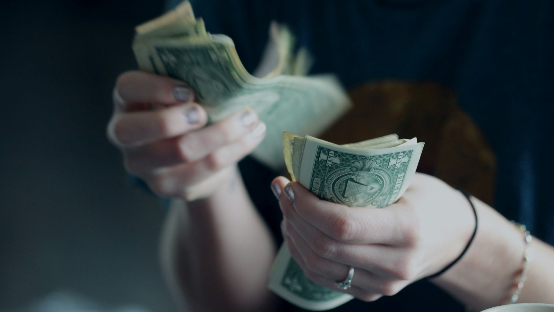 focus photography of person counting dollar banknotes