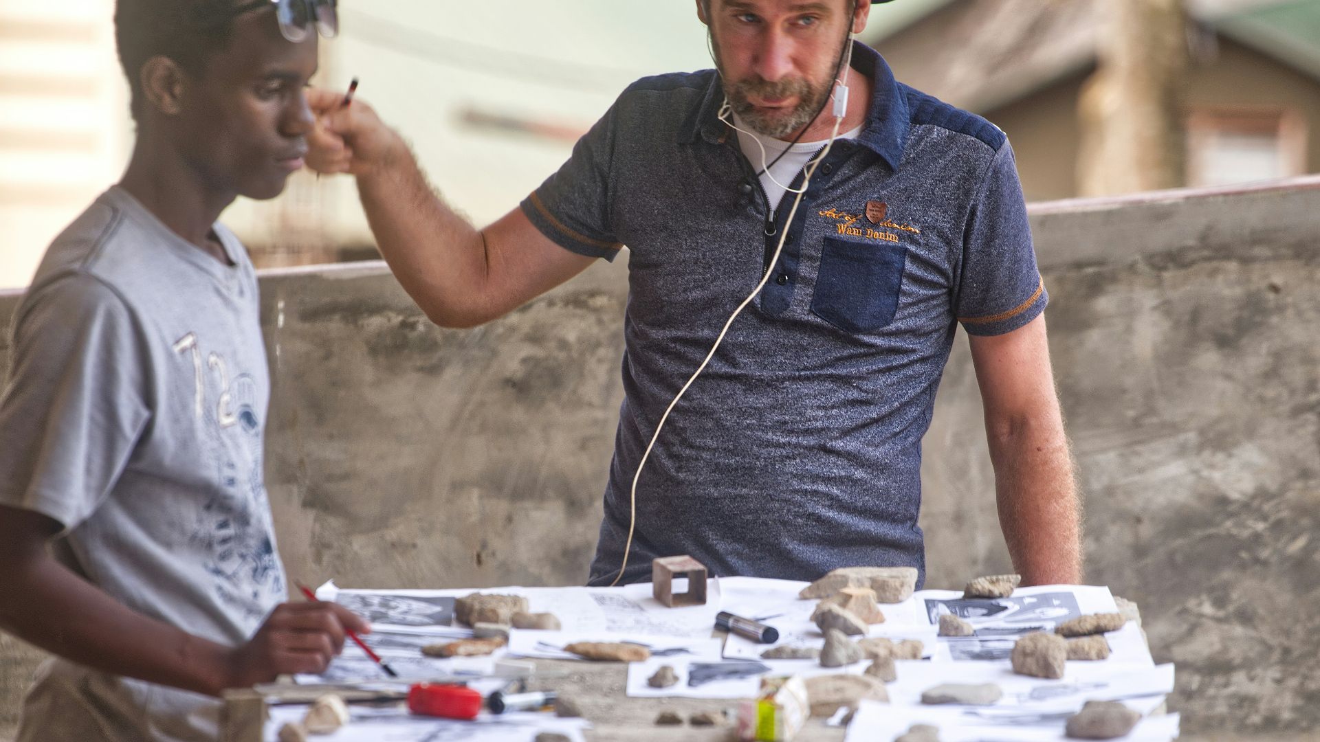 Two men examining artifacts on a table