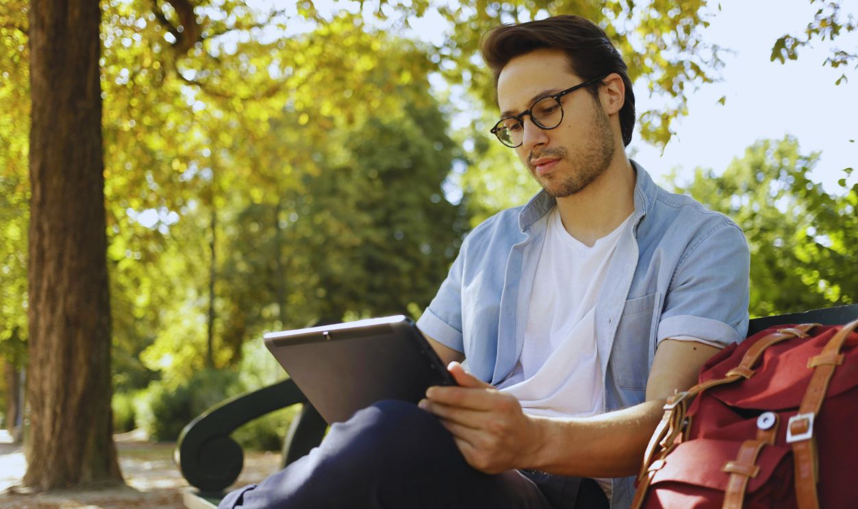 Man in White Dress Shirt and Black Pants Sitting on Bench