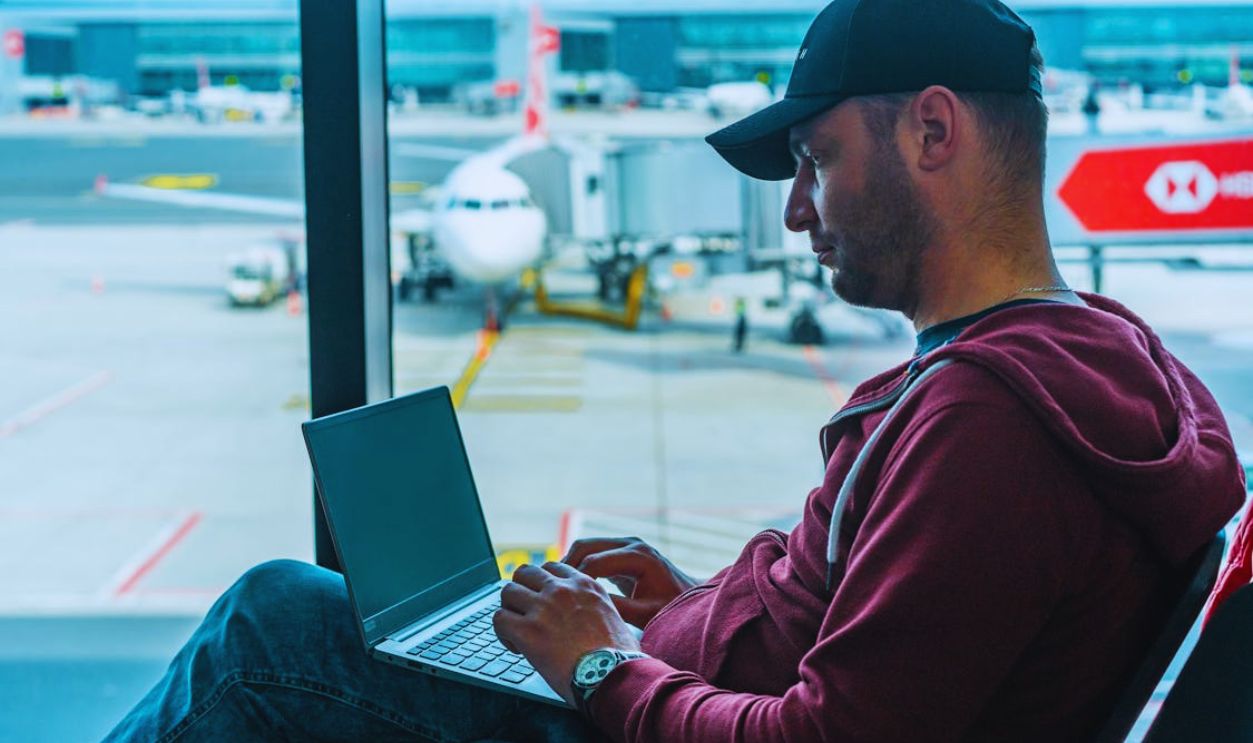 Man in Hoodie Jacket Sitting on a Chair Using Laptop